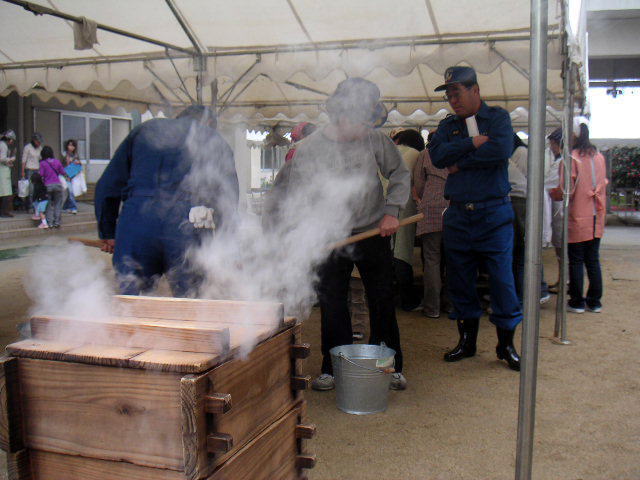 せいろからは湯気がモウモウと!テントの中では消防団の方々による餅つきが。