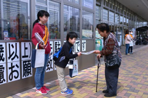 「気をつけてね」と啓発グッズを手渡す母の会の母子 「気をつけてね」と啓発グッズを手渡す母の会の母子