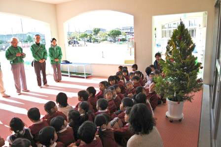 クリスマスツリーを背にお礼を言う園児 クリスマスツリーを背にお礼を言う園児