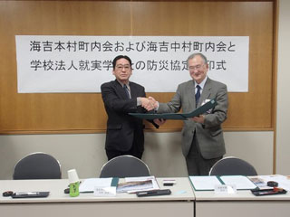 調印を終えた小橋会長と西井理事長 調印を終えた小橋会長と西井理事長