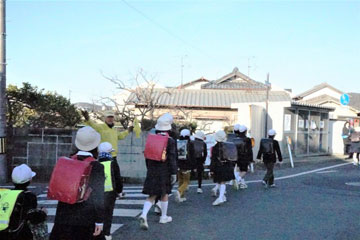見守り隊やPTAの役員に迎えられて通学する児童(福泊地内) 見守り隊やPTAの役員に迎えられて通学する児童(福泊地内)