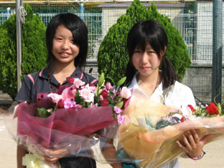 激励の花束を贈られた両選手(向かって左:持田、右:伊丹) 激励の花束を贈られた両選手(向かって左:持田、右:伊丹)