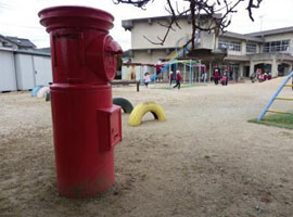 園庭で遊ぶ園児たちを見守る赤いポスト 園庭で遊ぶ園児たちを見守る赤いポスト