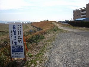 旧堤防を掘り下げる工事を知らせる看板(北側から南を望む) 旧堤防を掘り下げる工事を知らせる看板(北側から南を望む)