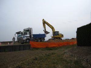 パワーショベルで掘り下げた土砂をダンプカーに積み込む パワーショベルで掘り下げた土砂をダンプカーに積み込む