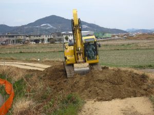 パワーショベルで旧堤防を削り取る パワーショベルで旧堤防を削り取る